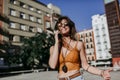 Beautiful young caucasian woman walking at the city street on a sunny day. Talking on mobile phone. Happy face smiling. Urban Royalty Free Stock Photo