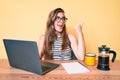 Beautiful young caucasian woman working at the office using computer laptop pointing thumb up to the side smiling happy with open Royalty Free Stock Photo