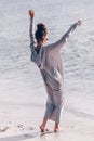 Beautiful young cheerful fashion model having fun on the beach at sunset