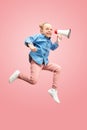 Beautiful young child teen girl jumping with megaphone isolated over pink background Royalty Free Stock Photo