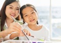 beautiful young children happy, smile, look at camera, mixing art painting color with teacher in education classroom. asian Royalty Free Stock Photo