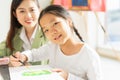 beautiful young children smile on face, happy, wear white shirt, look at camera, hold paintbrush in education classroom. asian Royalty Free Stock Photo