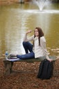 Beautiful young woman sits on college campus in fall alone Royalty Free Stock Photo