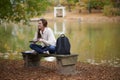 Beautiful young woman sits on college campus in fall alone Royalty Free Stock Photo