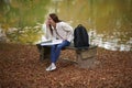 Beautiful young woman sits on college campus in fall alone Royalty Free Stock Photo