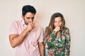 Beautiful young couple of boyfriend and girlfriend together feeling unwell and coughing as symptom for cold or bronchitis Royalty Free Stock Photo