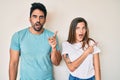 Beautiful young couple of boyfriend and girlfriend together surprised pointing with finger to the side, open mouth amazed Royalty Free Stock Photo