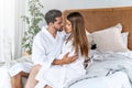 Beautiful young couple celebrating Saint Valentine`s Day, spending romantic time together at home, wearing white bathrobes and Royalty Free Stock Photo