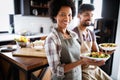 Beautiful young couple cooking healthy food together at home. Having fun in the kitchen. Royalty Free Stock Photo