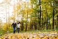 Beautiful young couple with dog running in autumn forest Royalty Free Stock Photo