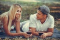 Beautiful young couple drinking red wine on a picnic in park Royalty Free Stock Photo