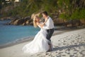 Beautiful young couple enjoying sunset, walking barefoot on beach and playing with each other.