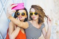 Beautiful young couple fashionable girls blonde and brunette in a bright yellow dress and sunglasses posing and smiling for the ca Royalty Free Stock Photo