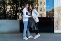 Beautiful young couple goes shopping and carries bags. Man and woman are holding black shopping bags after shopping Royalty Free Stock Photo