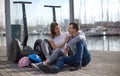 Young couple guy and girl are walking on the segway along the board paved promenade in the port of a European city Royalty Free Stock Photo