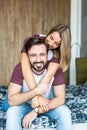 Happy couple. Beautiful young couple having fun in bedroom at home while shirtless man giving his girlfriend piggy back ride Royalty Free Stock Photo