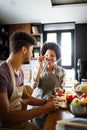 Beautiful young couple having fun and laughing while cooking in kitchen Royalty Free Stock Photo