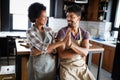 Beautiful young couple having fun and laughing while cooking in kitchen Royalty Free Stock Photo