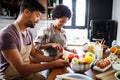 Beautiful young couple having fun and laughing while cooking in kitchen Royalty Free Stock Photo