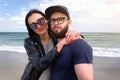 Beautiful young couple of hipsters in fashionable clothes on the background of the sea.Bearded guy, t-shirt, blue baseball cap, Royalty Free Stock Photo