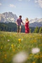 Beautiful young couple holding hands and running on green meadow. Mountains in background. Fun, togetherness, lifestyle, nature Royalty Free Stock Photo