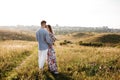 Beautiful young couple hugging in a field with grass at sunset. stylish man and woman having fun outdoors. family concept. copy Royalty Free Stock Photo