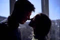 beautiful young couple kissing in the backlight against the window Royalty Free Stock Photo