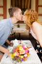 A beautiful young couple is kissing in a cafe. Summer vacation with your beloved Royalty Free Stock Photo