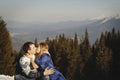 Beautiful couple kissing outdoors over amazingly snowy mountains