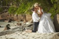 Beautiful young couple kissing on sunset, standing barefoot on b