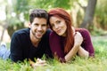 Beautiful young couple laying on grass in an urban park. Royalty Free Stock Photo