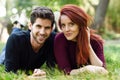 Beautiful young couple laying on grass in an urban park. Royalty Free Stock Photo