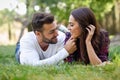 Beautiful young couple laying on grass in an urban park. Royalty Free Stock Photo