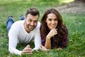 Beautiful young couple laying on grass in an urban park. Royalty Free Stock Photo