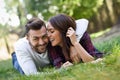 Beautiful young couple laying on grass in an urban park. Royalty Free Stock Photo