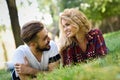 Beautiful young couple laying on grass in an urban park. Royalty Free Stock Photo