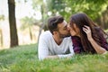 Beautiful young couple laying on grass in an urban park. Royalty Free Stock Photo