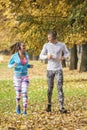 Beautiful young couple listening music and running together in the park Royalty Free Stock Photo