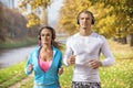 Beautiful young couple listening music and running together in the park Royalty Free Stock Photo