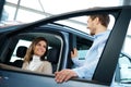 Beautiful young couple looking a new car at the dealership showroom Royalty Free Stock Photo