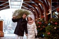 Beautiful young couple in love buying a Christmas tree from the market to decorate their home. Caucasian man and woman Royalty Free Stock Photo