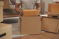 Beautiful young couple in love having fun unpacking things from cardboard boxes while moving in together in their new apartment Royalty Free Stock Photo