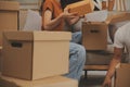 Beautiful young couple in love having fun unpacking things from cardboard boxes while moving in together in their new apartment Royalty Free Stock Photo