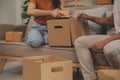 Beautiful young couple in love having fun unpacking things from cardboard boxes while moving in together in their new apartment Royalty Free Stock Photo