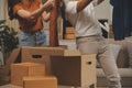 Beautiful young couple in love having fun unpacking things from cardboard boxes while moving in together in their new apartment Royalty Free Stock Photo