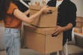 Beautiful young couple in love having fun unpacking things from cardboard boxes while moving in together in their new apartment Royalty Free Stock Photo