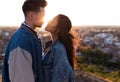 Beautiful young couple in love standing at a building rooftop at the sunset. Royalty Free Stock Photo