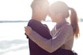 Beautiful young couple in love walking on the shore of the lake at sunset in the rays of bright light Royalty Free Stock Photo