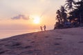 Beautiful young couple in love whirls holding hands on the beach at sunset during the honeymoon vacation travel Royalty Free Stock Photo