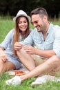 Young couple making a wish after finding four leaf clover while enjoying picnic in a park